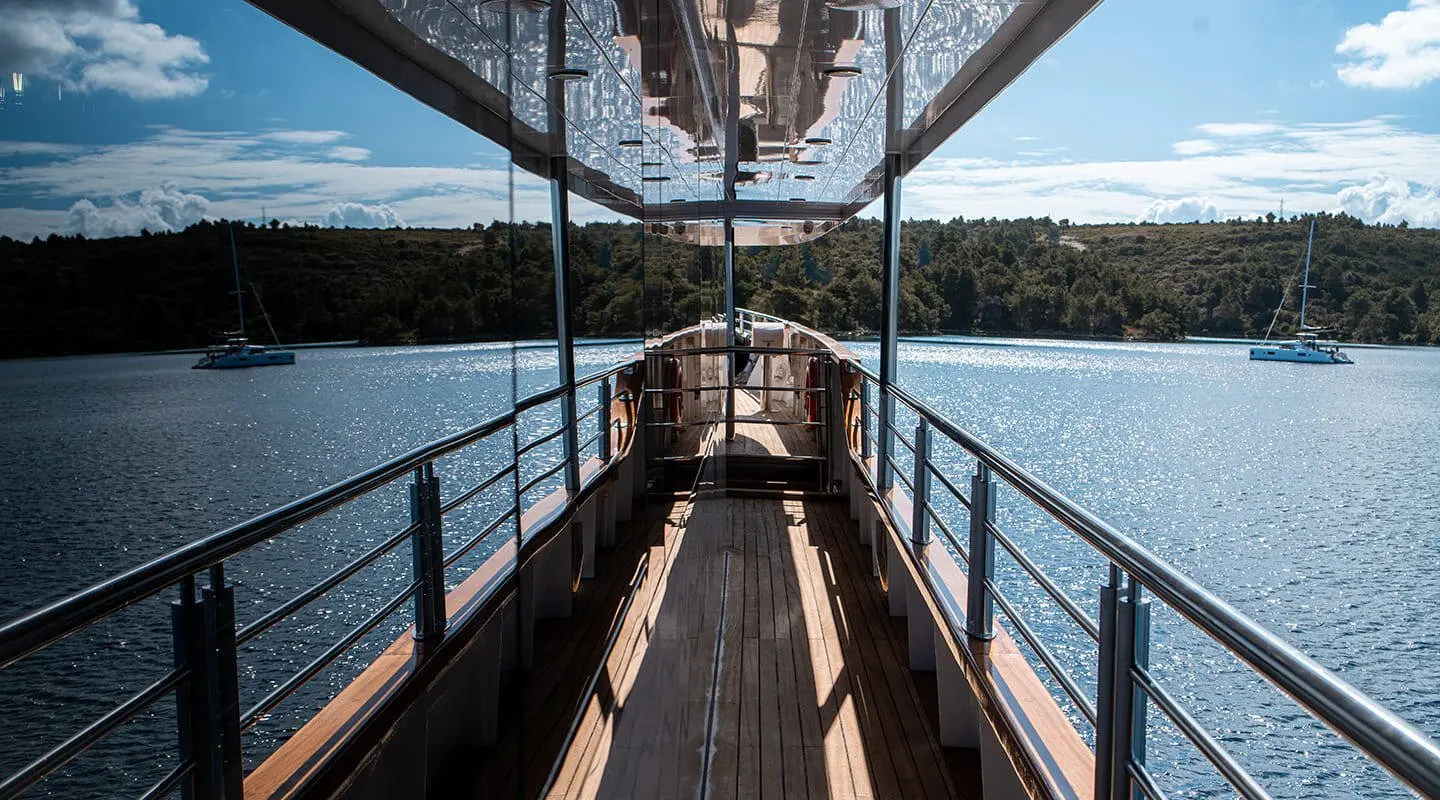 Cristal yacht deck walkway at sunset with railings and water horizon