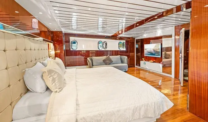 Master cabin on Esma Sultan yacht with large bed and wooden accents