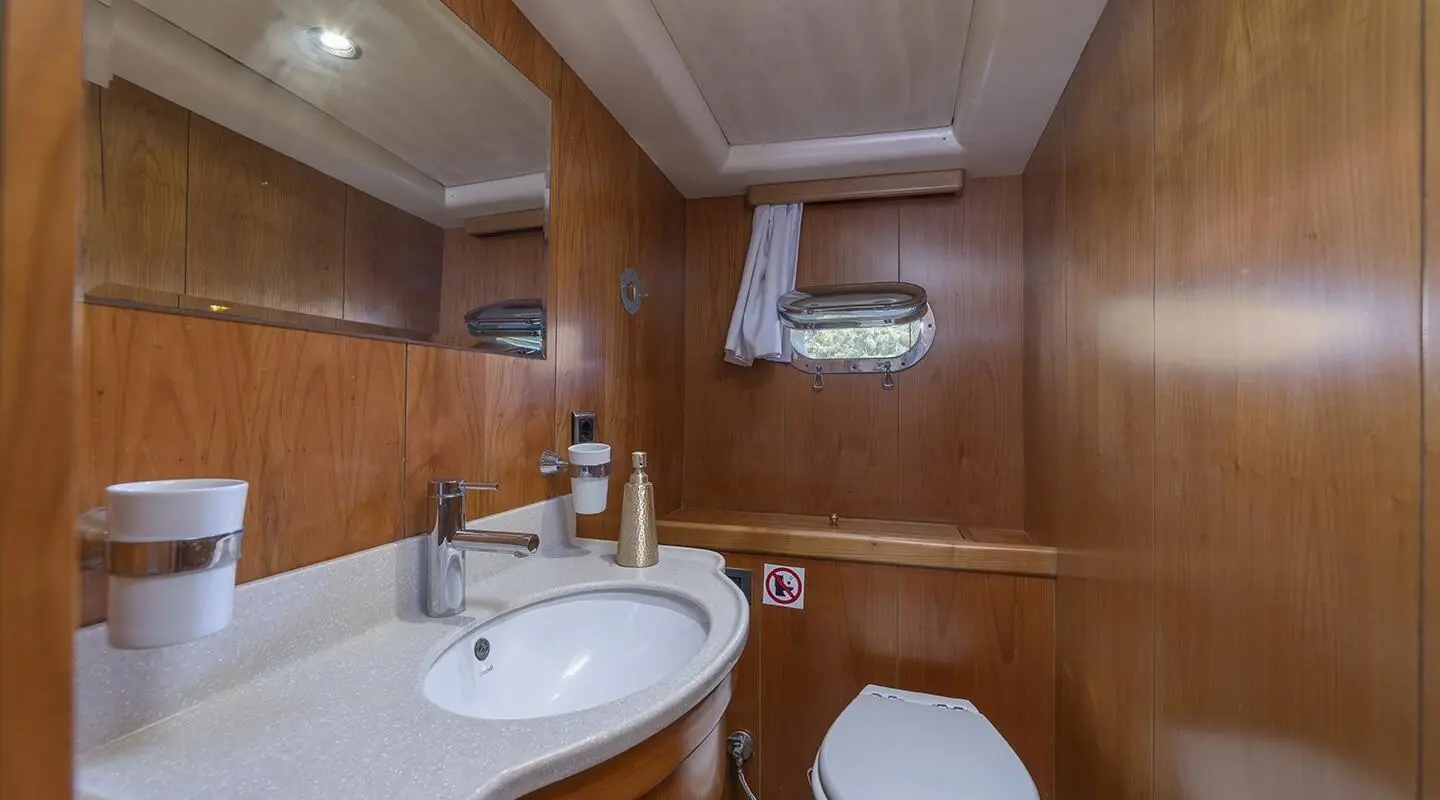 Interior of Queen Of Sea yacht with wooden panels, sink and mirror visible