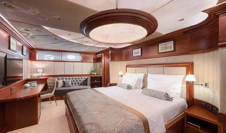 Lady Gita cabin with king bed, ensuite, warm lighting, wood paneling, round ceiling fixture