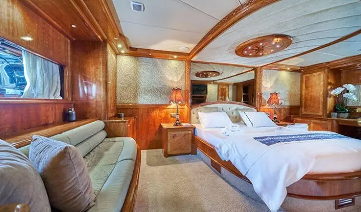 Master cabin with king bed, ensuite, wood paneling, soft lighting, seating area