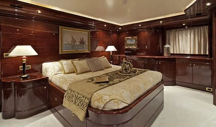 Master cabin with king bed, beige linens, wood paneling, ensuite fixtures
