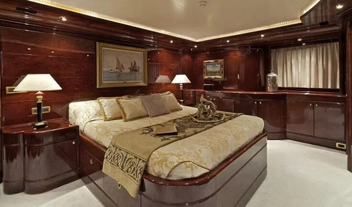 Master cabin with king bed, beige linens, wood paneling, ensuite fixtures