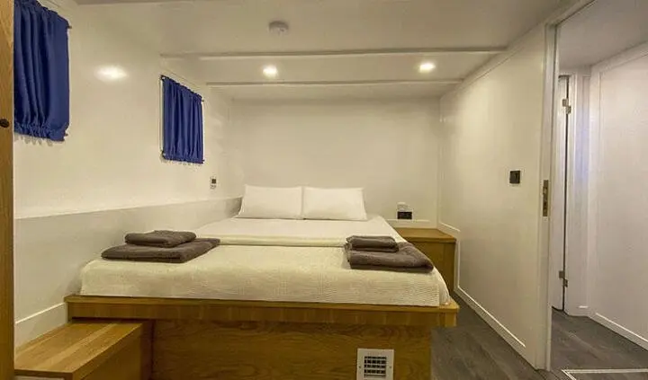 Maske 5 master cabin with large bed, beige walls, and wooden accents