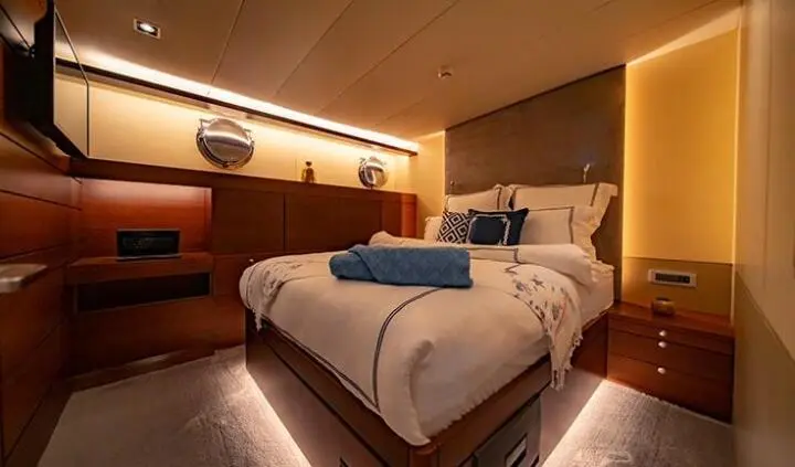 Double Eagle cabin bed with white linens and wood-paneled walls interior