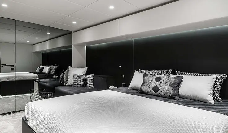 Master cabin with king bed and ensuite in yacht interior, neutral palette