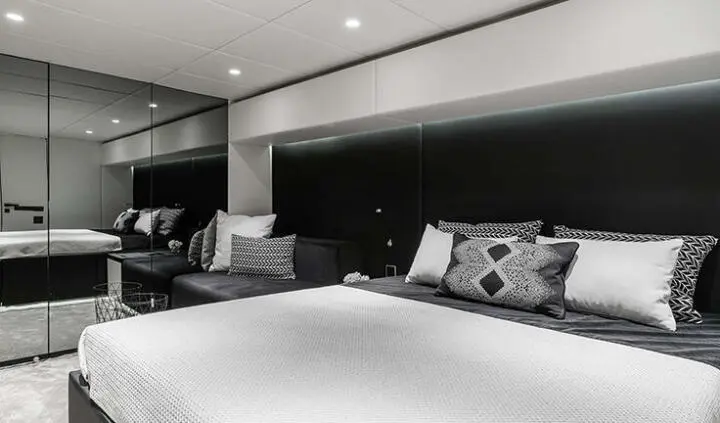 Master cabin with king bed and ensuite in yacht interior, neutral palette