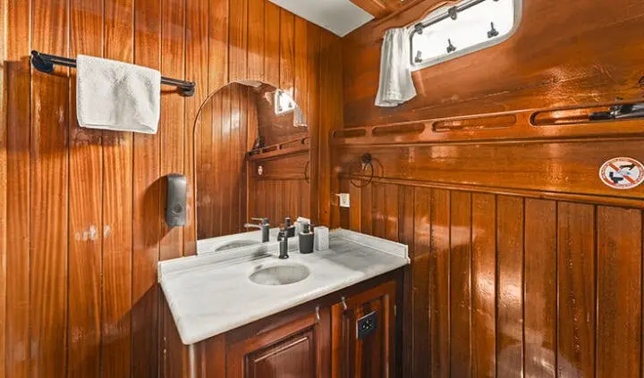 Croatia yacht cabin interior with polished wood panels, marble sink, and compact vanity