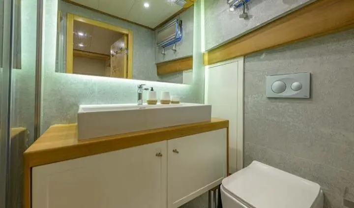 Master cabin with king bed, wood cabinetry, ensuite bathroom visible