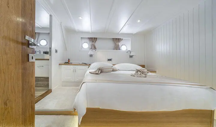Interior of Maske yacht cabin with two beds and white starboard decor