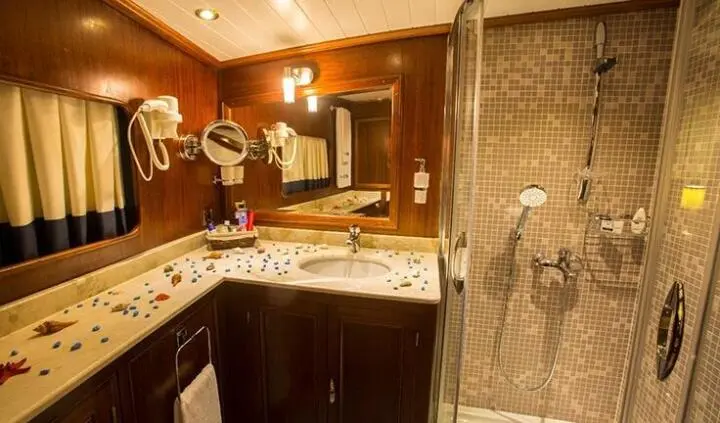 Master cabin with king bed, ensuite bathroom, wood tones, decorative lighting