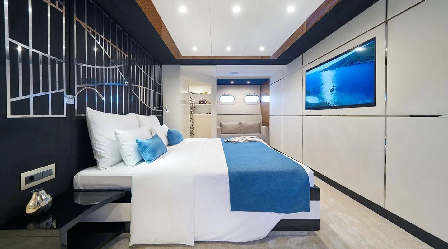 Acapella yacht interior with a large bed, blue accents, and modern cabin