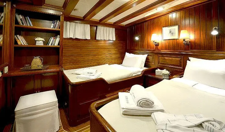 Cozy twin cabin on a wooden yacht interior with two single beds