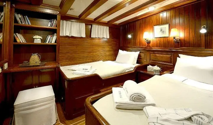 Cozy twin cabin on a wooden yacht interior with two single beds