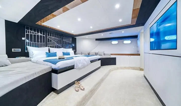 Master cabin on Acapella yacht with king bed, ensuite door, blue and white decor