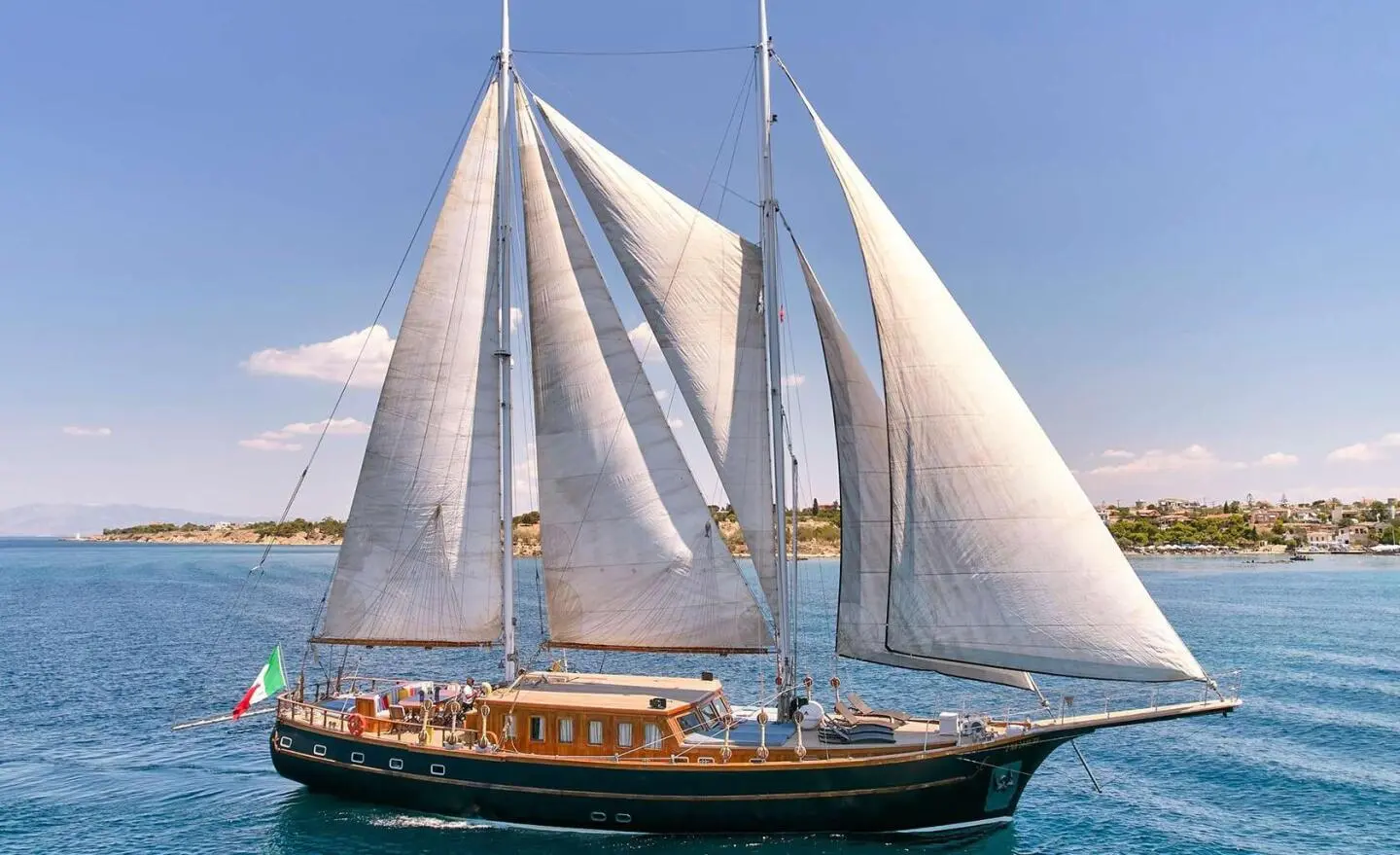 Myra luxury gulet with white sails billowing at sunset on calm blue sea