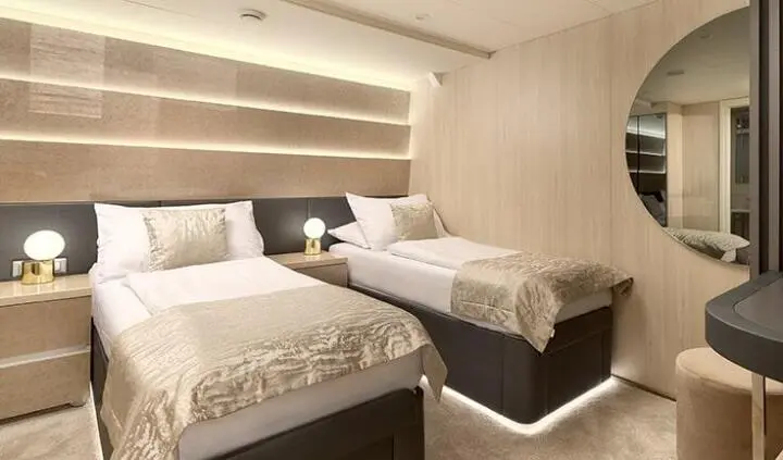 Twin cabin with two single beds and ensuite bunk-style bedding arrangement