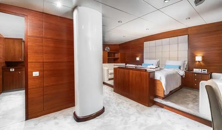Master cabin with king bed and ensuite, wooden cabinetry, curved white pillar