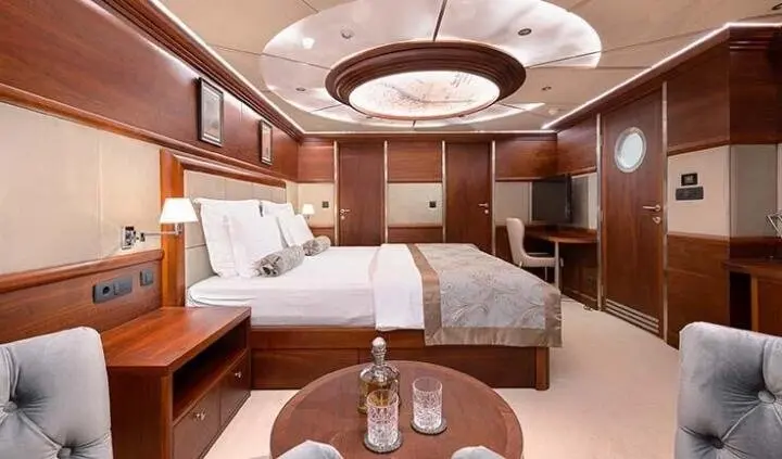 Lady Gita cabin interior with two beds, wooden panels, round ceiling light