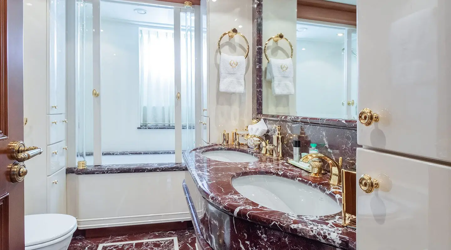 Luxurious bathroom on Apogee yacht with ornate fixtures and marble surfaces