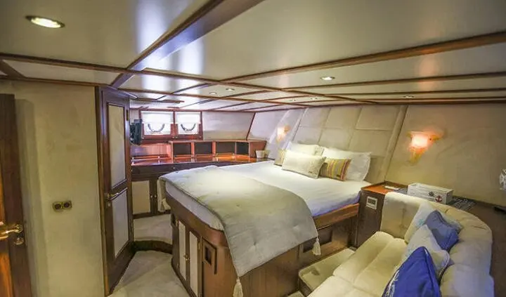 Gazella yacht cabin with wooden furniture and single bed setup in foreground