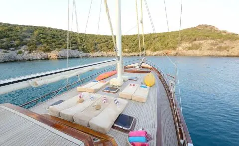 On the Samarkand yacht, sun loungers and cushions on the deck with water nearby