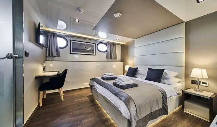 Master cabin with king bed, nightstands, and an ensuite area visible