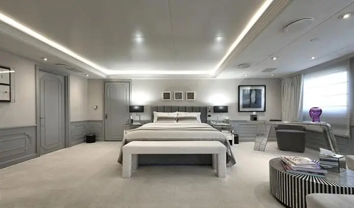 Chakra yacht cabin interior with plush bed, gray paneled walls, and ambient lighting