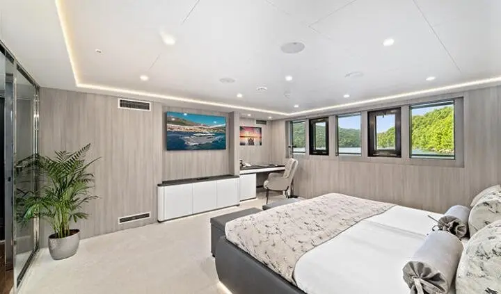 Master cabin with king bed, ensuite visible, windows along wall