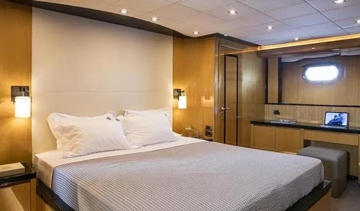 King bed in a cabin with white linens, nightstands, and wood paneling