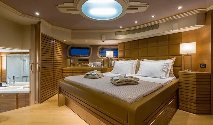 Master cabin with king bed, ensuite, warm wood panels, soft lighting