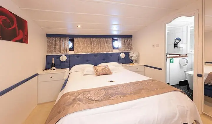Aurum yacht master cabin with king bed, beige decor, and twin nightstands