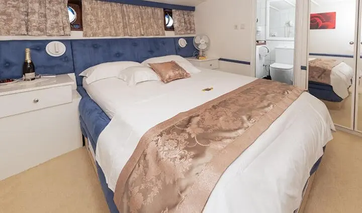 Aurum yacht cabin with two beds and a shared brown bedspread.