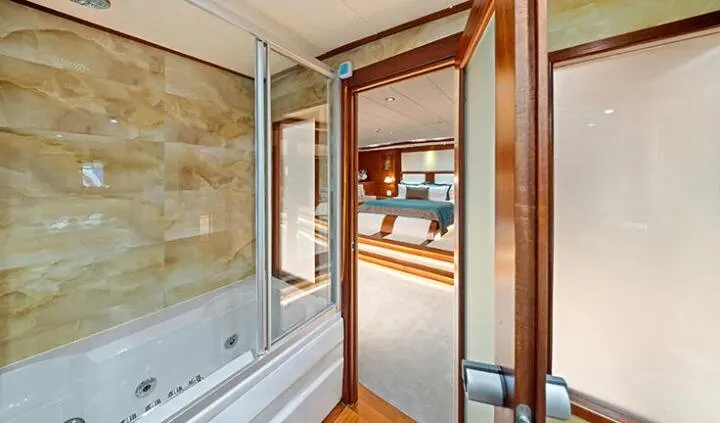 View from doorway into master cabin with king bed and ensuite bathroom