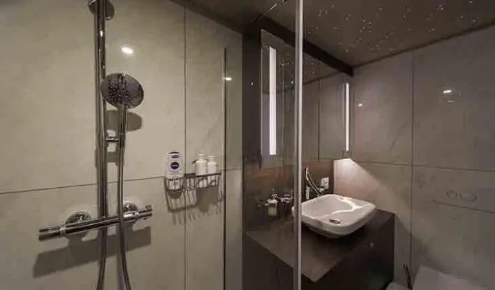 Omnia yacht master cabin with king bed and ensuite bathroom, dark wood accents