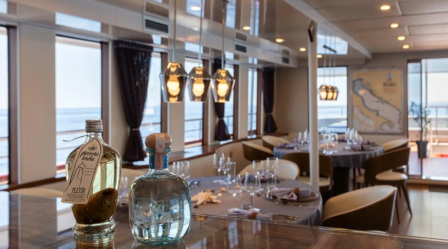 Yolo luxury yacht dining area at sunset with table setting and chandeliers