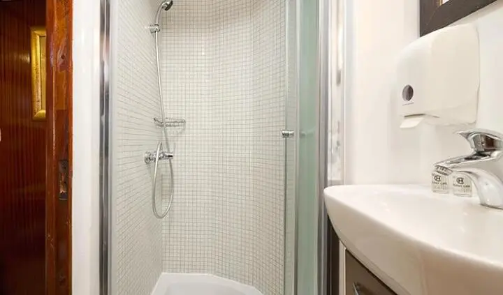 Linda yacht cabin interior with tiled shower, compact sink, and contemporary fixtures