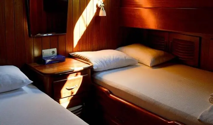 Twin cabin ensuite on Enderim A yacht with two single beds and wood paneling