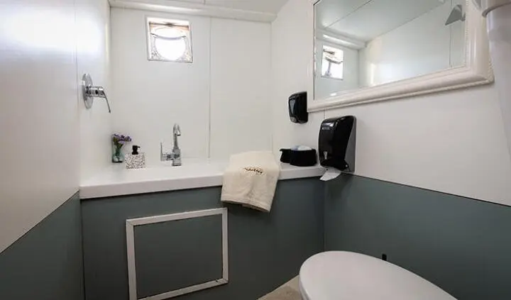 Cabin aboard Aborda yacht with bed, en-suite bathroom, white cabinetry