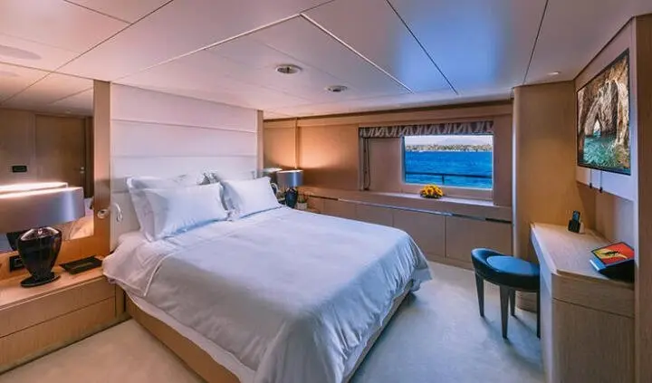 Xana yacht master cabin with king bed, white bedding, wood nightstands, ensuite mirror cabinet