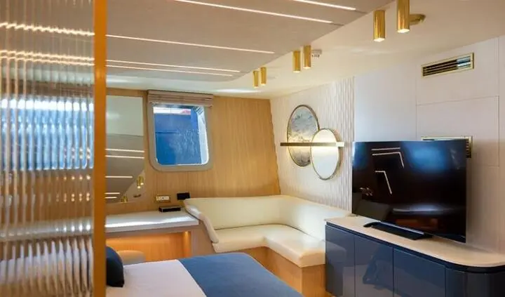 Scorpios yacht cabin with white seating, wood accents, and a flat-screen TV