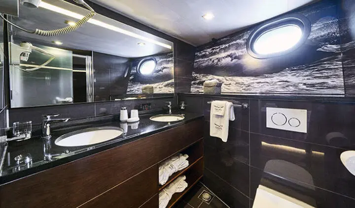 Rara Avis yacht cabin with king bed, dark wood cabinetry, ensuite