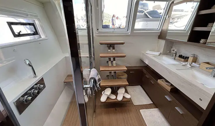 Master cabin with king bed, ensuite, wood flooring and seating area on yacht Atlantis