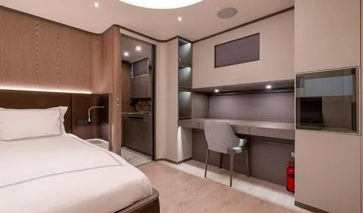 Good Life yacht cabin interior with a plush bed, built-in desk, and modern storage