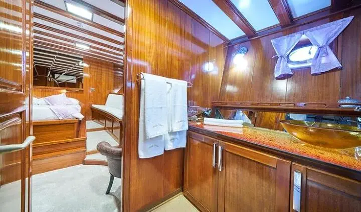 Stella Maris cabin interior with wooden cabinets, berth, and towels hanging