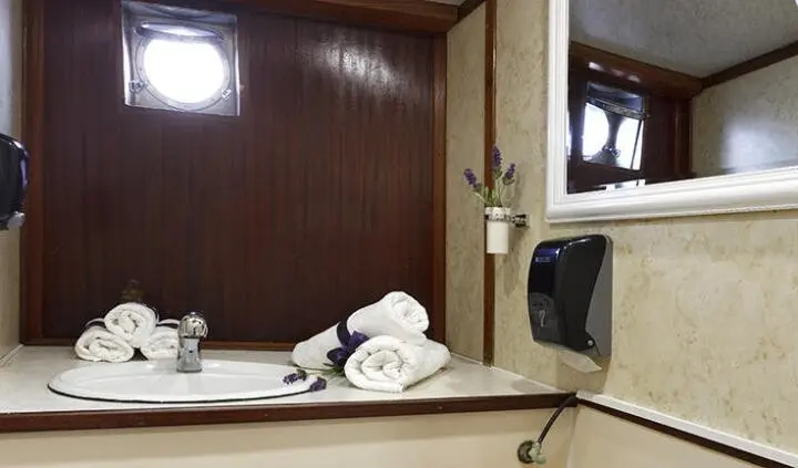 Bathroom on Aborda yacht cabin with towels and mirrored cabinet