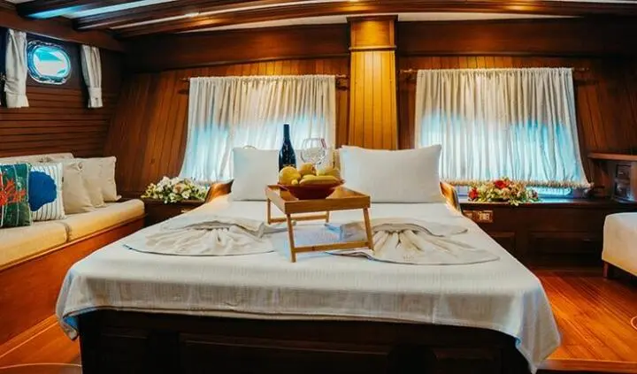 Master cabin with king bed, bedside nightstands, and ensuite door