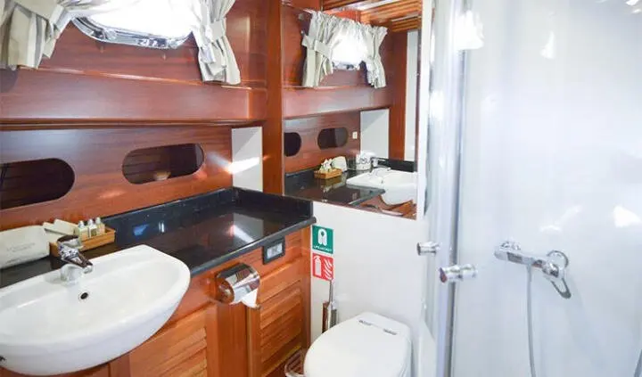 Interior cabin on Ros Mare gulet with wooden cabinetry and compact galley