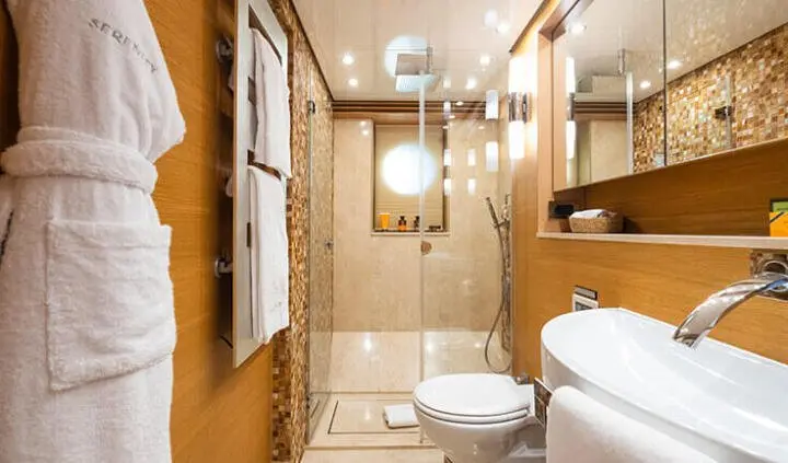 Cabin interior on Serenity yacht with bed, ensuite, wooden and tiled surfaces