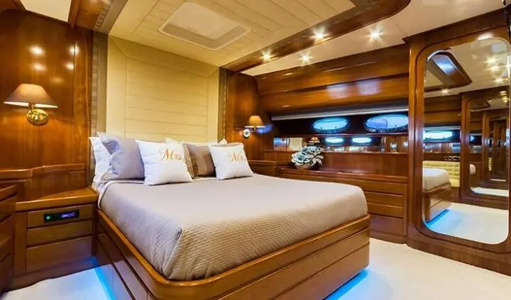 Master cabin with king bed, wood paneling, and ensuite bathroom in Amoraki yacht